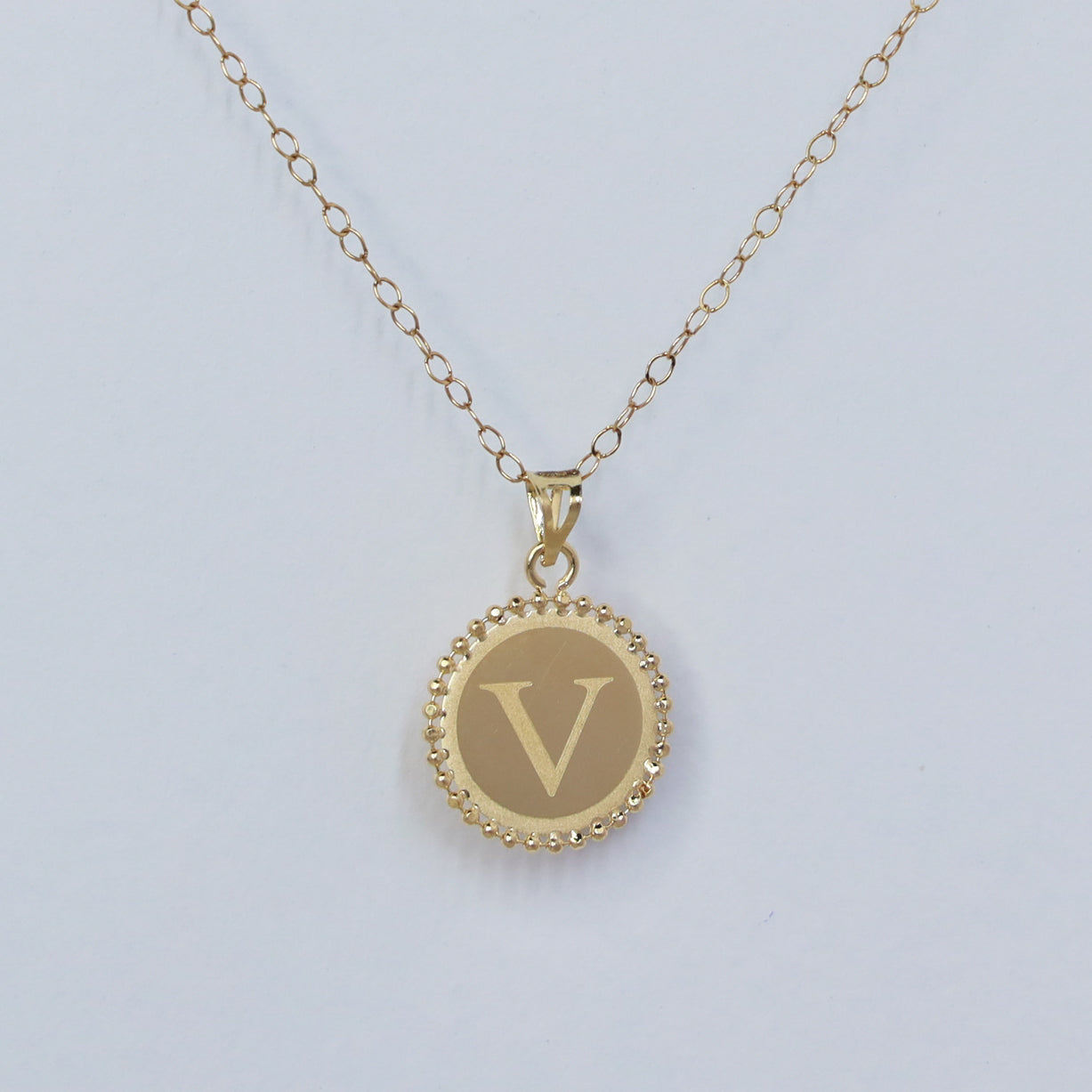 18kt gold letter v round pendant